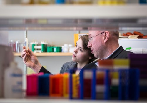 Ted Meigs looking at a culture in the lab with a student